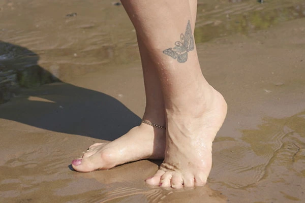 Damski tatuaż motyl na nodze